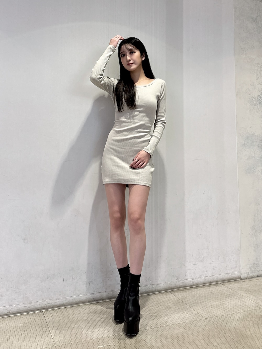 ホワイト系のワンピース、ブラック系のブーツを着用したレディースの冬コーディネートの2枚目の写真