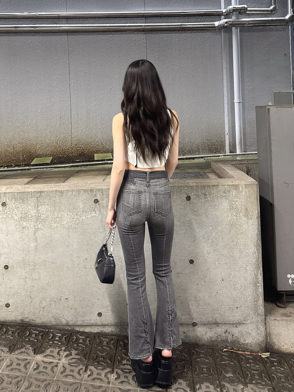 ホワイト系のニット/セーター、ブラック系のデニムパンツ、ブラック系のサンダルを着用したレディースの夏コーディネートの2枚目の写真