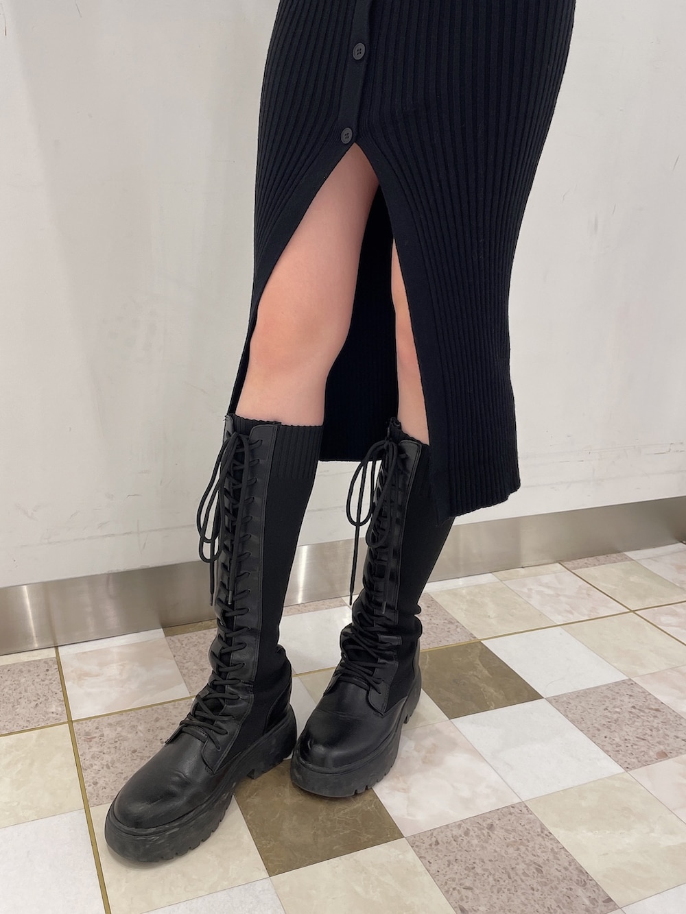 ブラック系のワンピース、ブラック系のブーツ、ホワイト系のボストンバッグを着用したレディースの秋コーディネートの7枚目の写真