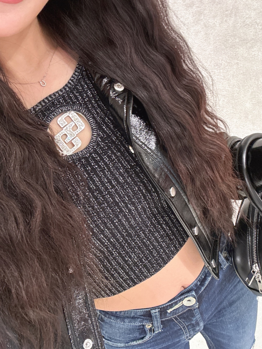 ブラック系のライダースジャケット、ブルー系のデニムパンツ、ブラック系のニット/セーターを着用したレディースの春コーディネートの4枚目の写真