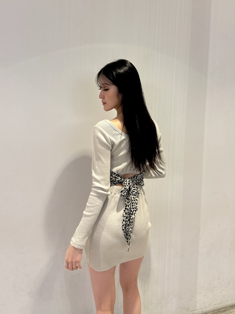 ホワイト系のワンピース、ブラック系のブーツを着用したレディースの冬コーディネートの3枚目の写真