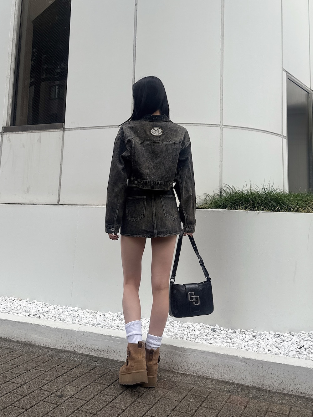 ブラック系のハンドバッグ、ブルー系のデニムジャケット、ブルー系のデニムスカートを着用したレディースの秋コーディネートの4枚目の写真