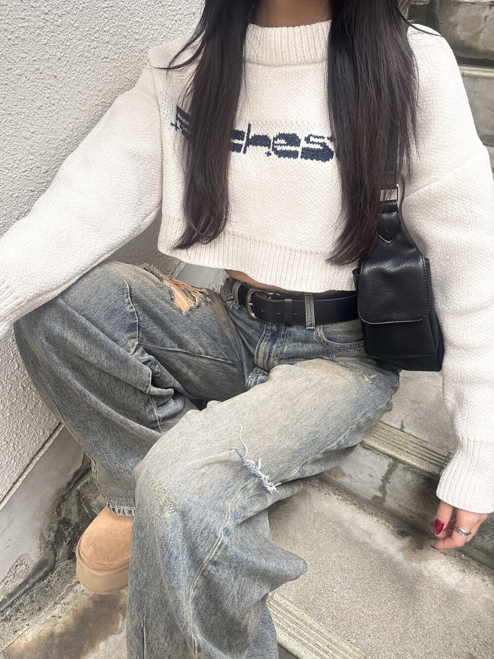 ホワイト系のニット/セーター、ブルー系のデニムパンツ、ブラック系のハンドバッグを着用したレディースの秋コーディネートの3枚目の写真