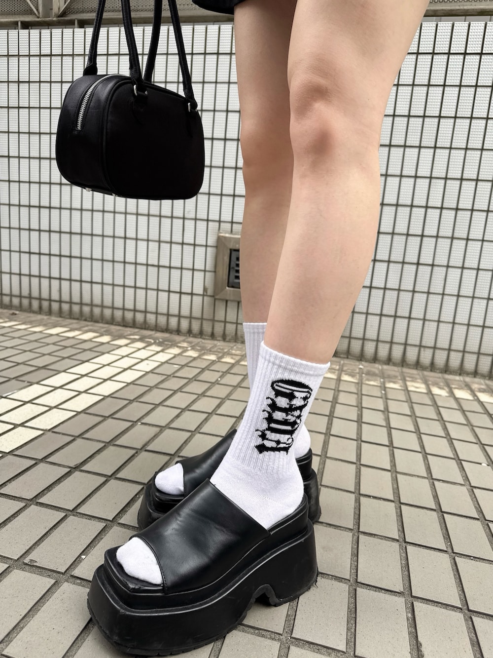 ブラック系のワンピース、ブラック系のボストンバッグ、ブラック系のキャップを着用したレディースの夏コーディネートの9枚目の写真