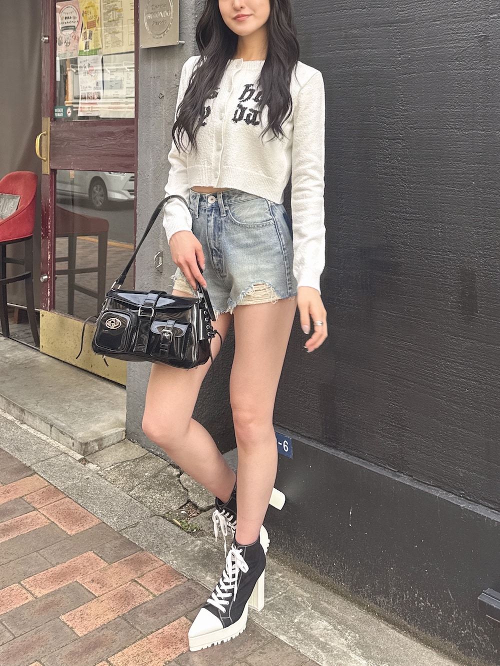 ブルー系のデニムパンツ、ブラック系のブーツ、ホワイト系のカーディガン/ボレロを着用したレディースの春コーディネートの4枚目の写真