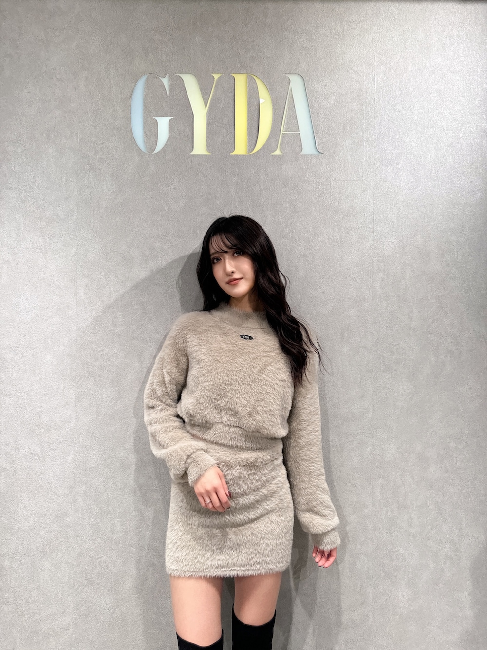 ベージュ系のニット/セーター、ベージュ系のスカート、ブラック系のブーツを着用したレディースの冬コーディネートの4枚目の写真