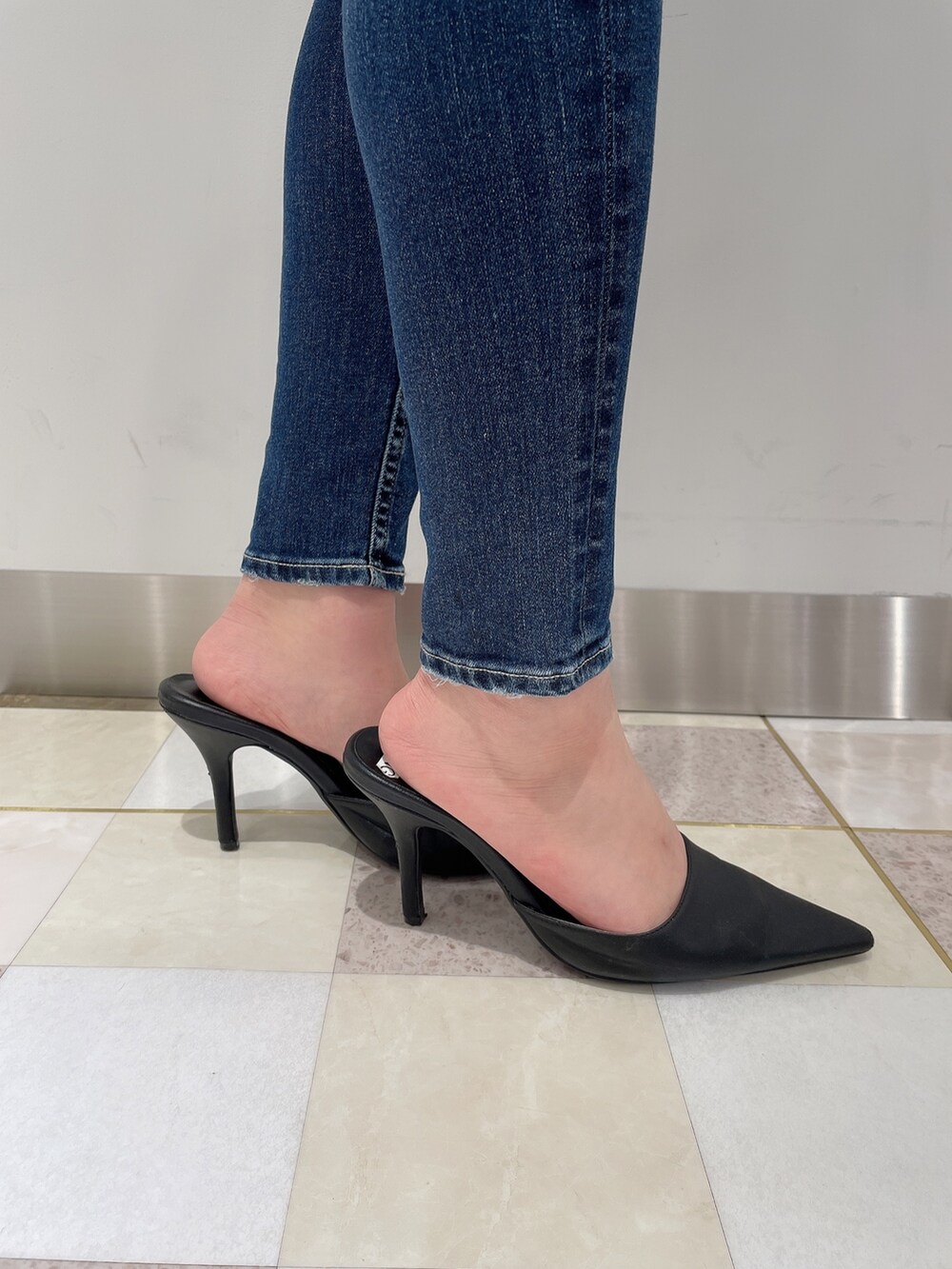 ブラック系のニット/セーター、ブルー系のデニムパンツ、ブラック系のパンプスを着用したレディースの秋コーディネートの7枚目の写真