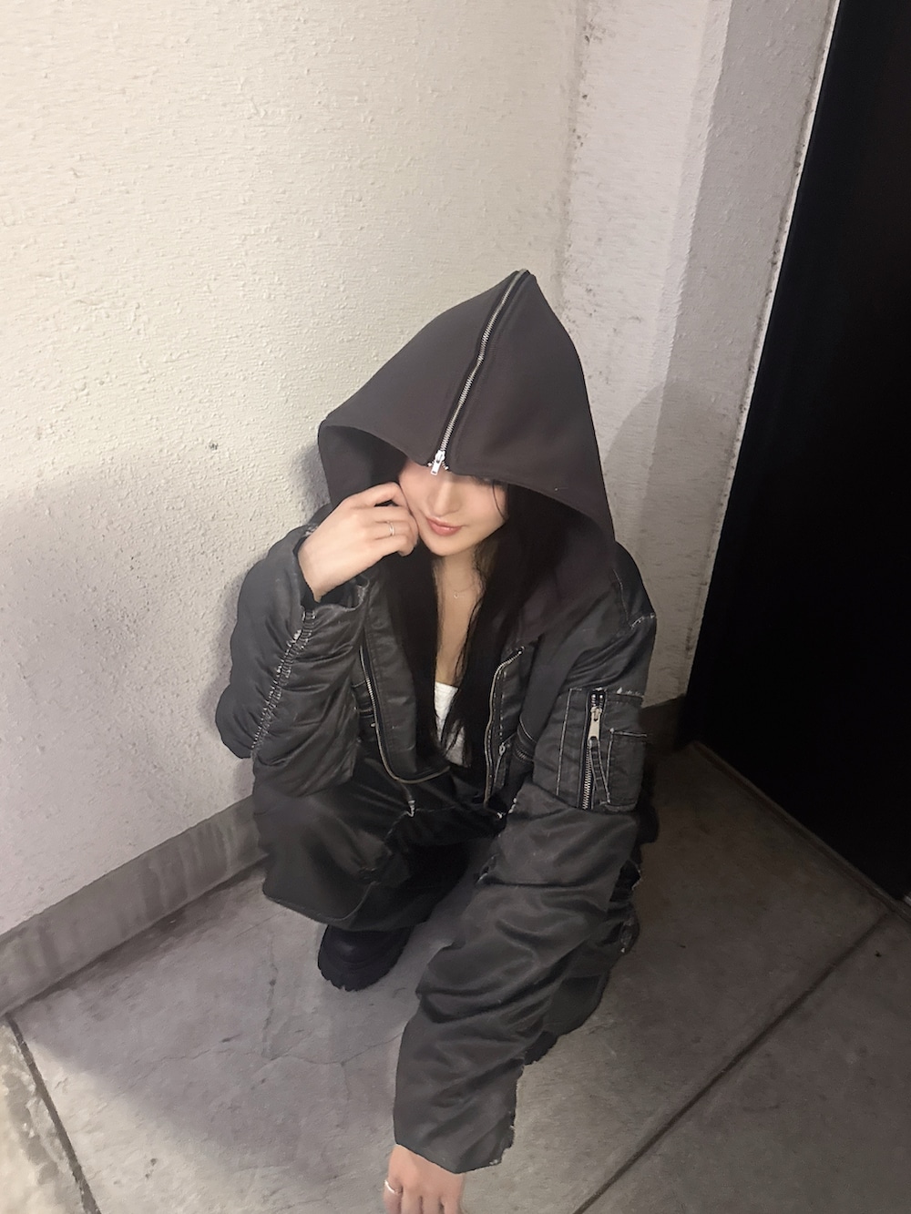 グレー系のブルゾン、ブラック系のブーツ、グレー系のその他パンツを着用したレディースの秋コーディネートの2枚目の写真