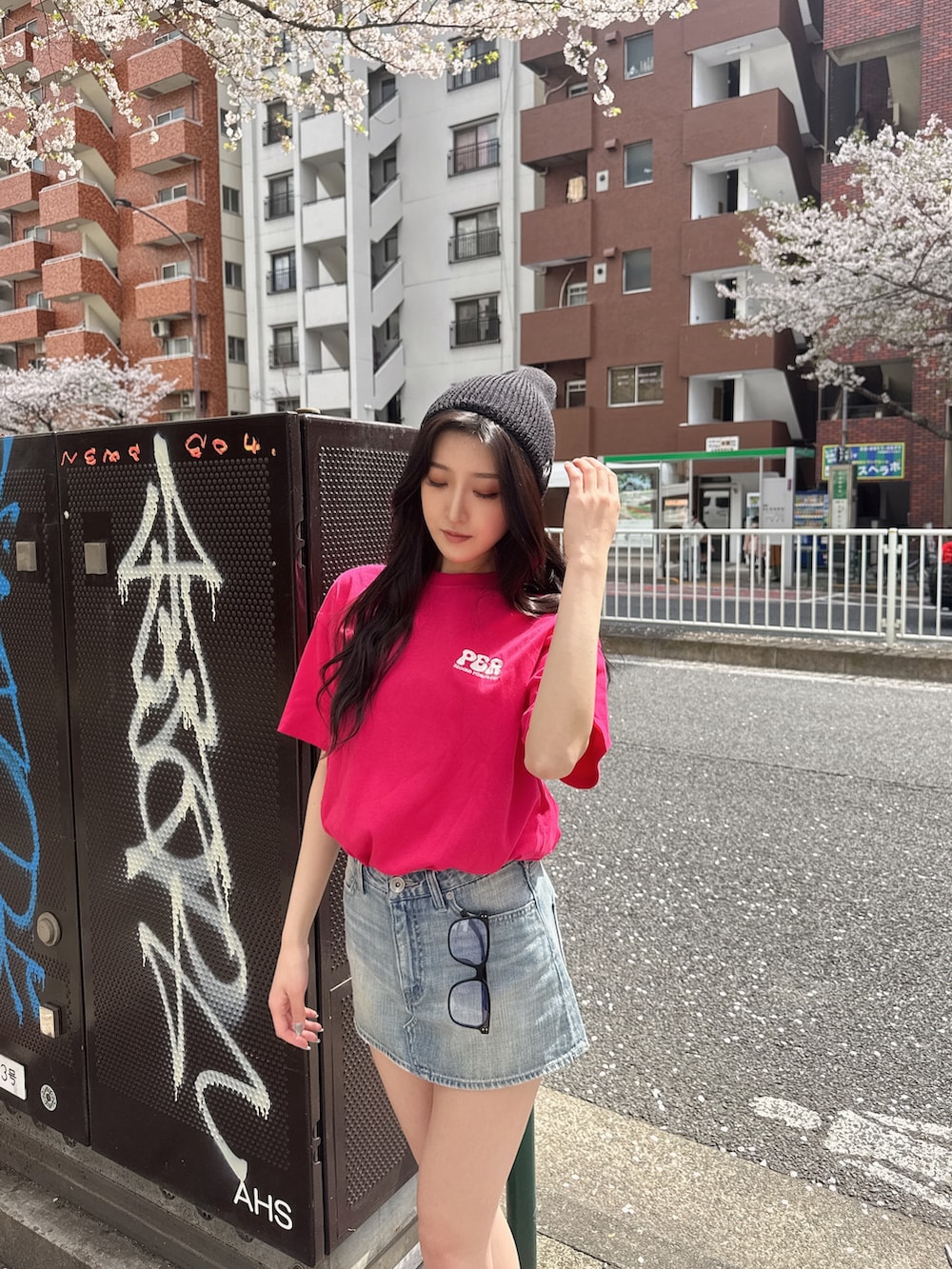 ピンク系のTシャツ/カットソー、ブルー系のデニムスカート、ブラック系のスニーカーを着用したレディースの春コーディネートの3枚目の写真