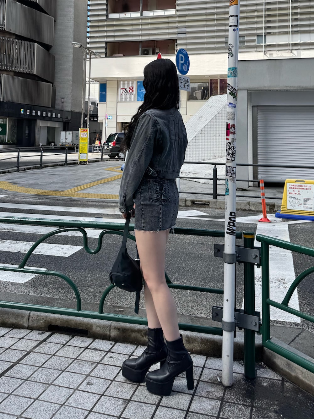 ブラック系のワンピース、ブラック系のデニムジャケット、ブラック系のハンドバッグを着用したレディースの春コーディネートの4枚目の写真