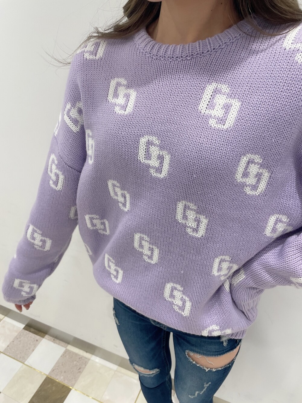 パープル系のニット/セーター、ブルー系のデニムパンツ、ブラック系のブーツを着用したレディースの冬コーディネートの5枚目の写真
