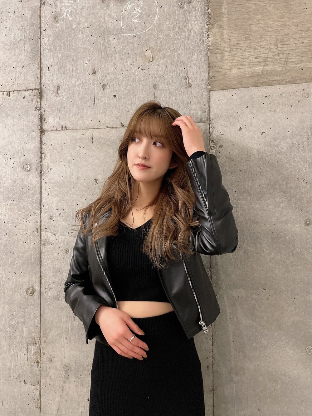 ブラック系のニット/セーター、ブラック系のスカート、ブラック系のライダースジャケットを着用したレディースの冬コーディネートの4枚目の写真