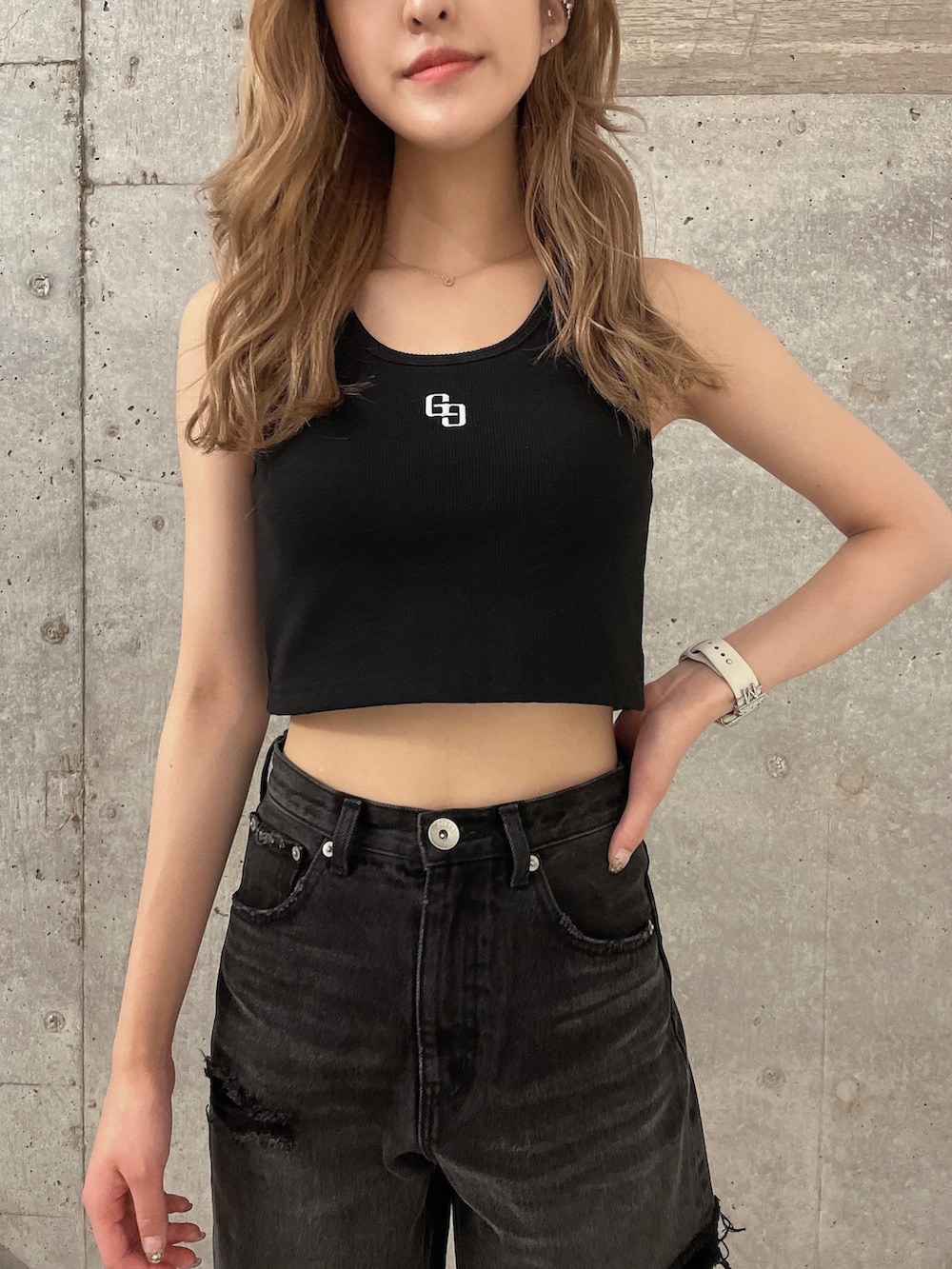 ブラック系のデニムパンツ、ブラック系のタンクトップ、ブラック系のパンプスを着用したレディースの夏コーディネートの4枚目の写真