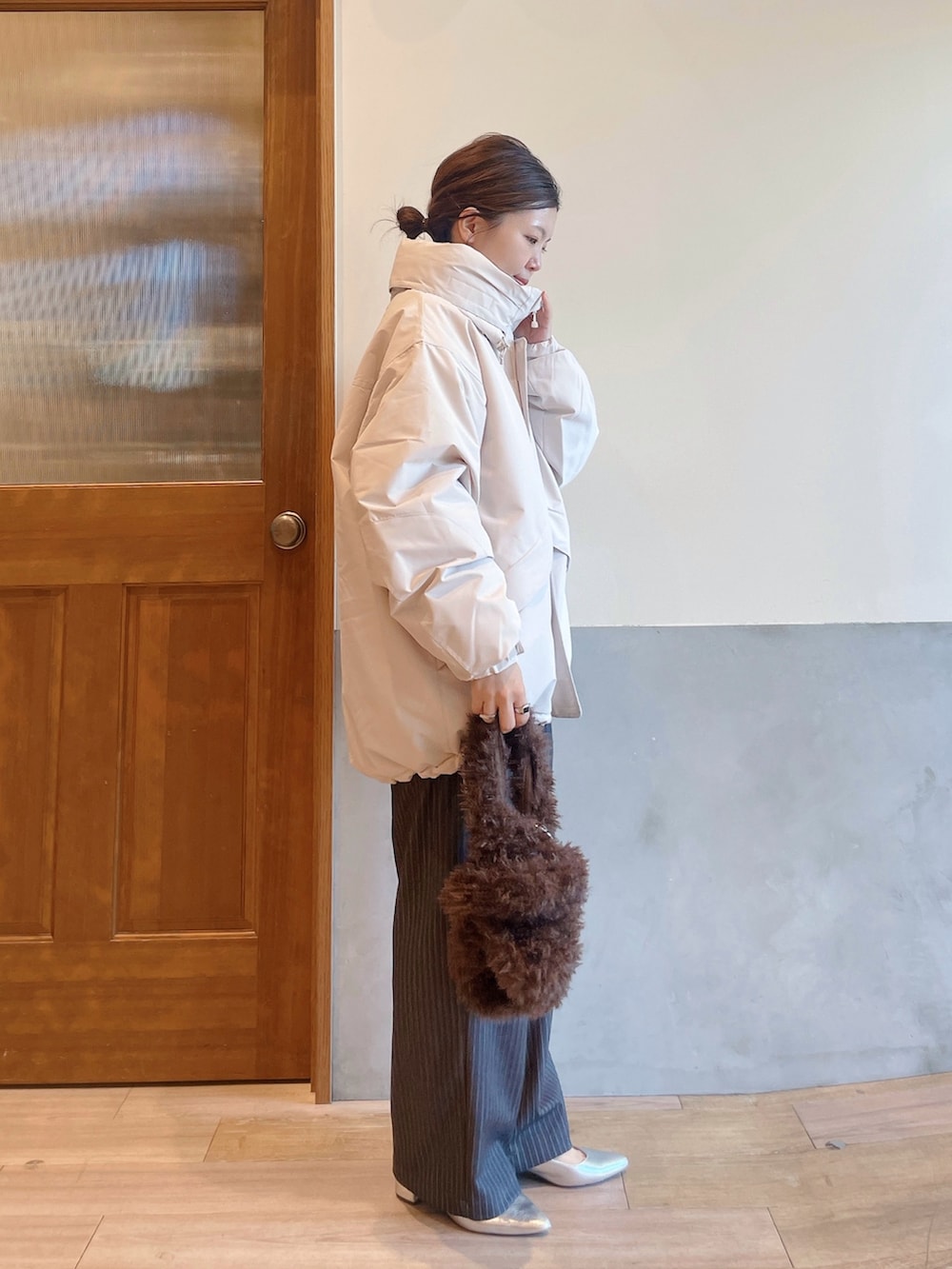 ホワイト系のダウンジャケット/コート、ホワイト系のニット/セーター、グレー系のスラックスを着用したレディースの秋コーディネートの2枚目の写真