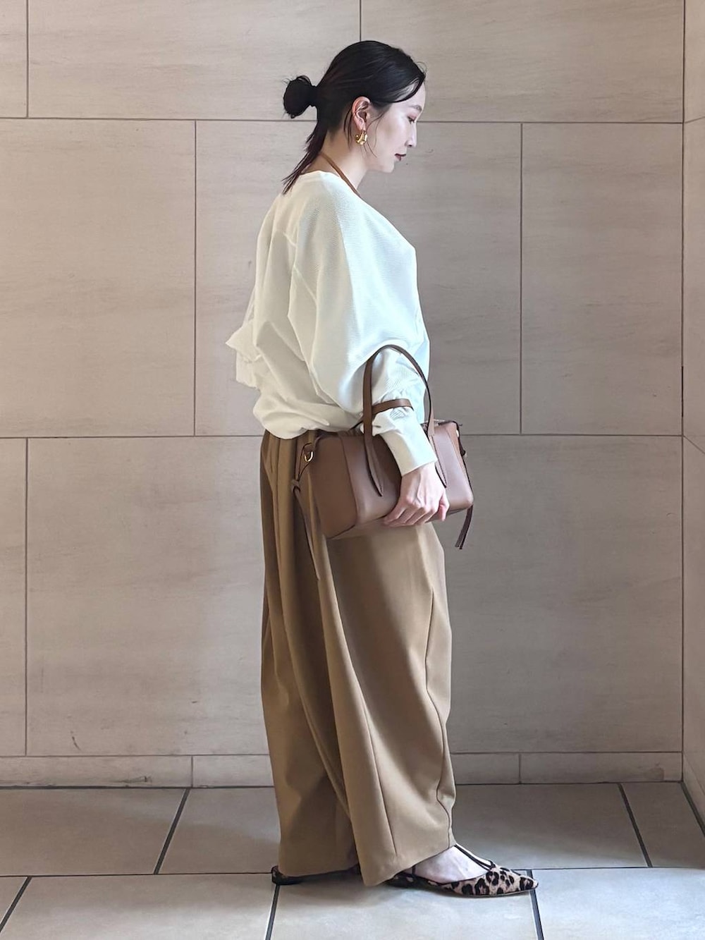 イエロー系のその他パンツ、ホワイト系のTシャツ/カットソー、ゴールド系のピアス(両耳用)を着用したレディースの冬コーディネートの2枚目の写真