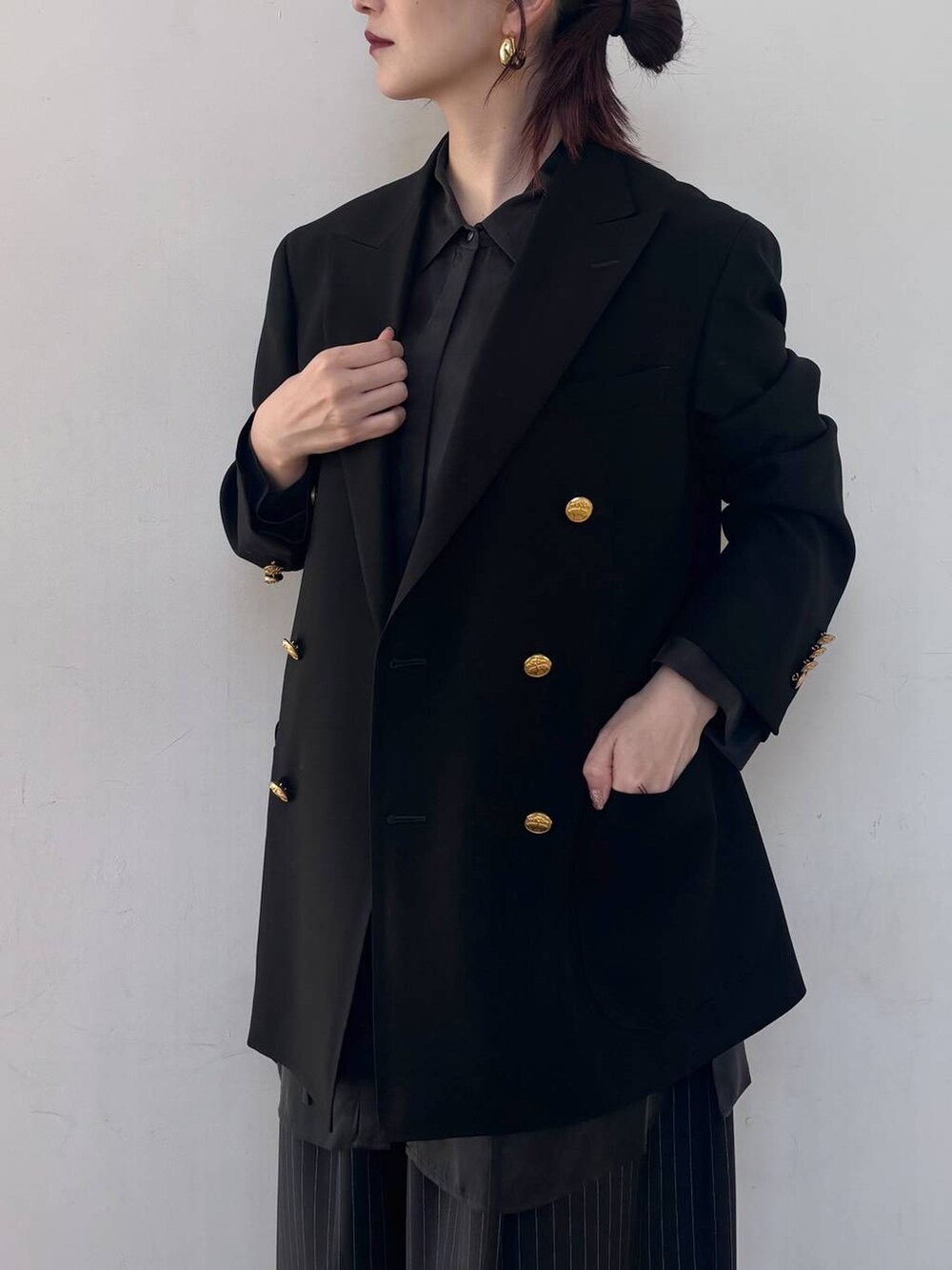 ブラック系のシャツ/ブラウス、ゴールド系のピアス(両耳用)を着用したレディースの冬コーディネートの5枚目の写真