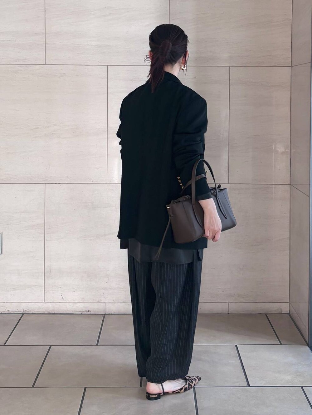 ブラック系のシャツ/ブラウス、ゴールド系のピアス(両耳用)を着用したレディースの冬コーディネートの3枚目の写真