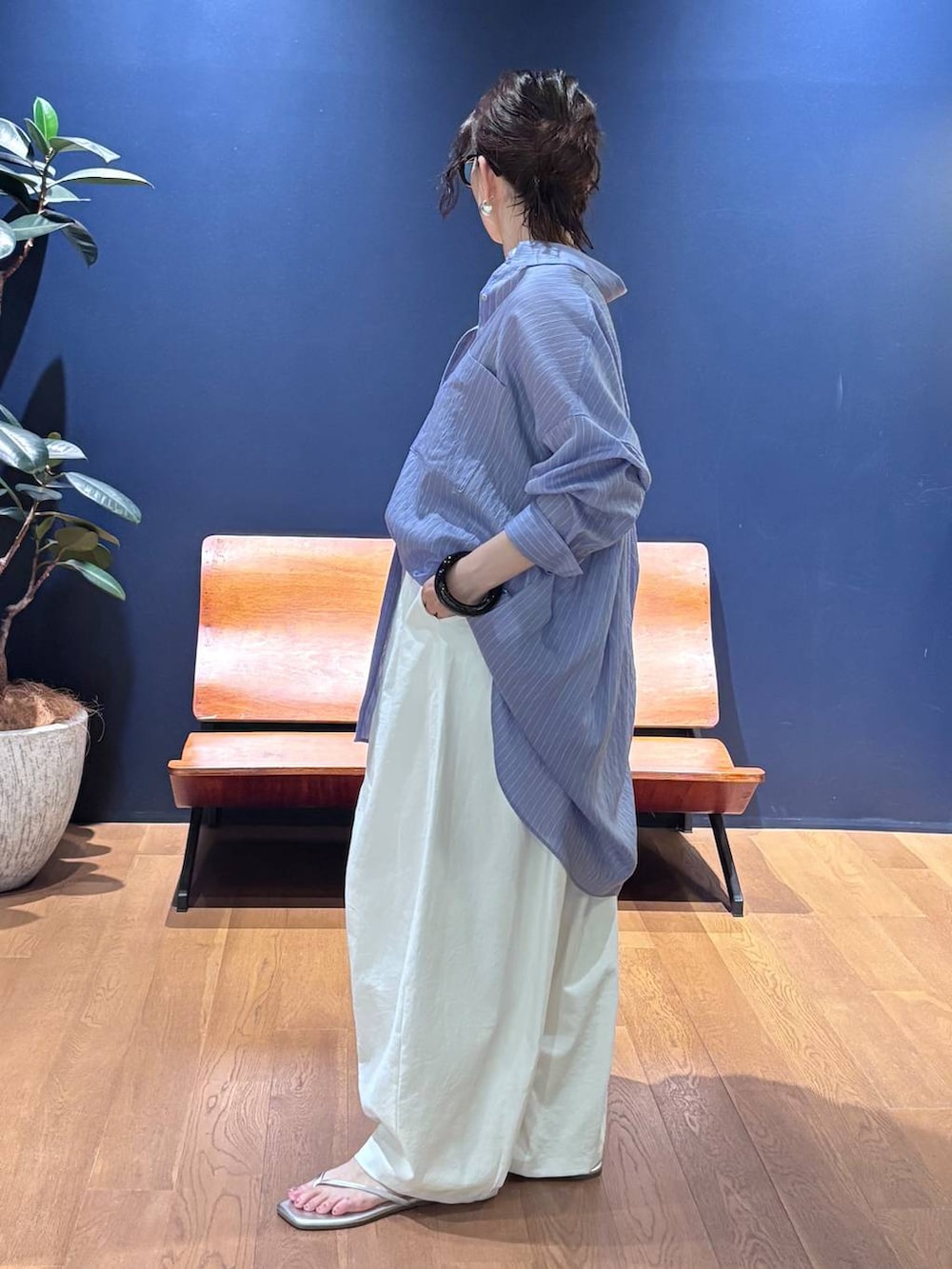 グリーン系のトートバッグ、ホワイト系のその他パンツ、ブルー系のシャツ/ブラウスを着用したレディースの夏コーディネートの2枚目の写真