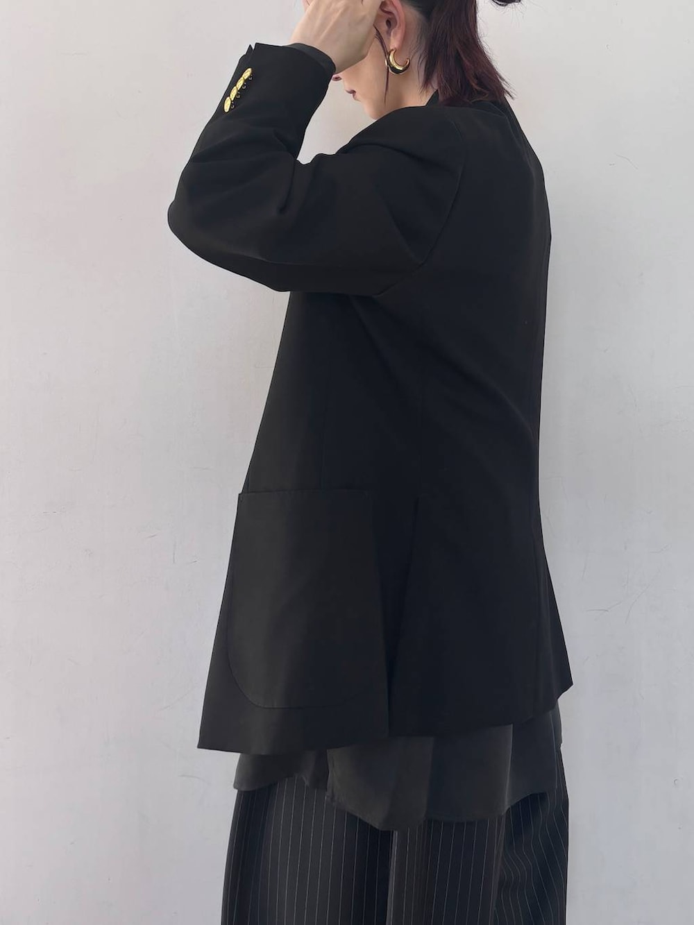 ブラック系のシャツ/ブラウス、ゴールド系のピアス(両耳用)を着用したレディースの冬コーディネートの6枚目の写真