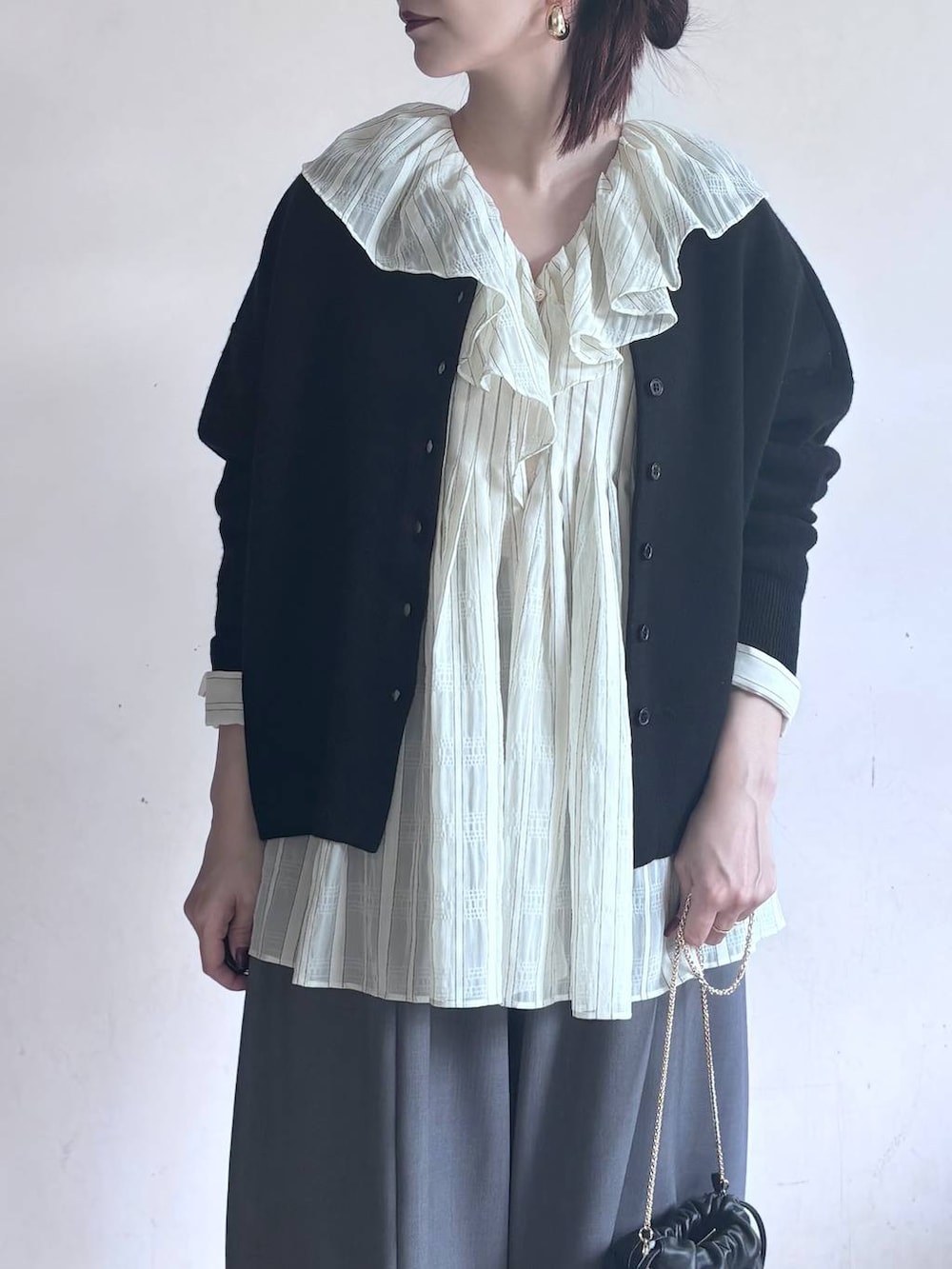 グレー系のその他パンツ、ブラック系のカーディガン/ボレロ、ゴールド系のピアス(両耳用)を着用したレディースの秋コーディネートの4枚目の写真