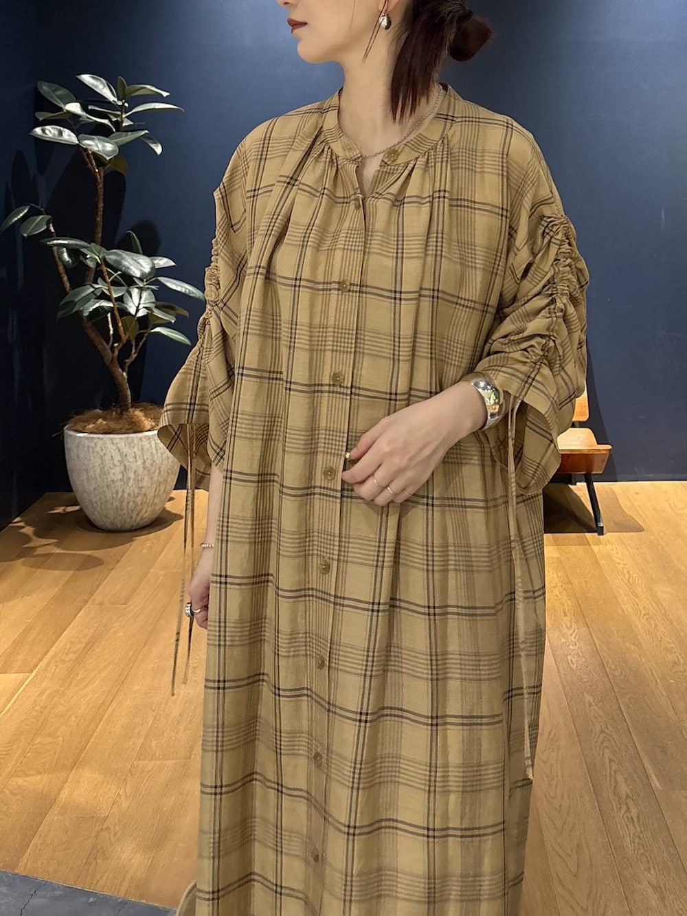 ベージュ系のワンピース、シルバー系のバングル/リストバンド、シルバー系のピアス(両耳用)を着用したレディースの春コーディネートの3枚目の写真