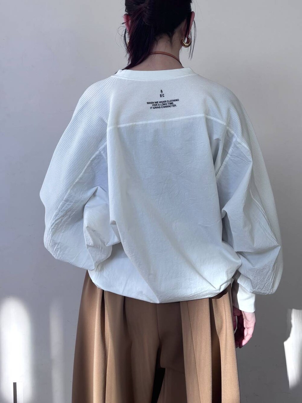 イエロー系のその他パンツ、ホワイト系のTシャツ/カットソー、ゴールド系のピアス(両耳用)を着用したレディースの冬コーディネートの5枚目の写真