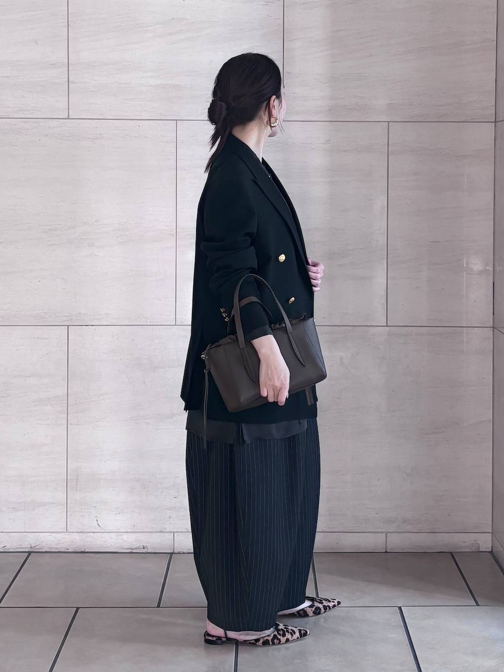 ブラック系のシャツ/ブラウス、ゴールド系のピアス(両耳用)を着用したレディースの冬コーディネートの2枚目の写真