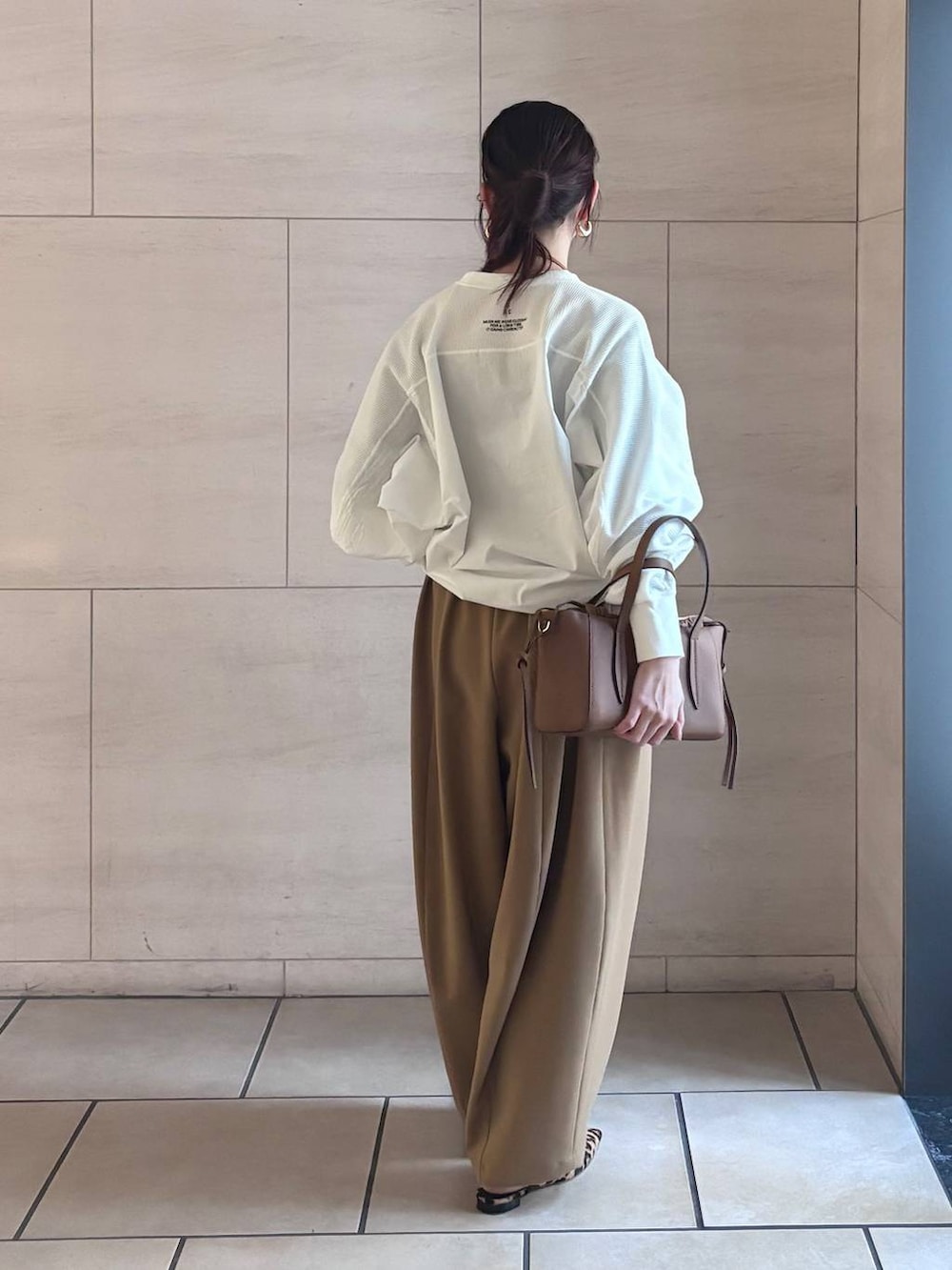 イエロー系のその他パンツ、ホワイト系のTシャツ/カットソー、ゴールド系のピアス(両耳用)を着用したレディースの冬コーディネートの3枚目の写真