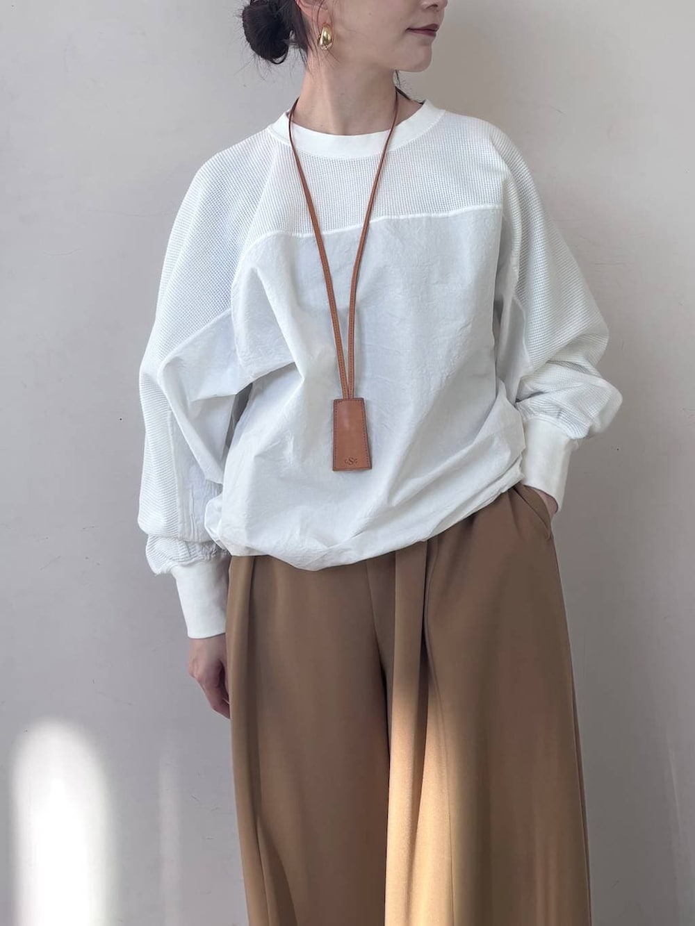 イエロー系のその他パンツ、ホワイト系のTシャツ/カットソー、ゴールド系のピアス(両耳用)を着用したレディースの冬コーディネートの4枚目の写真