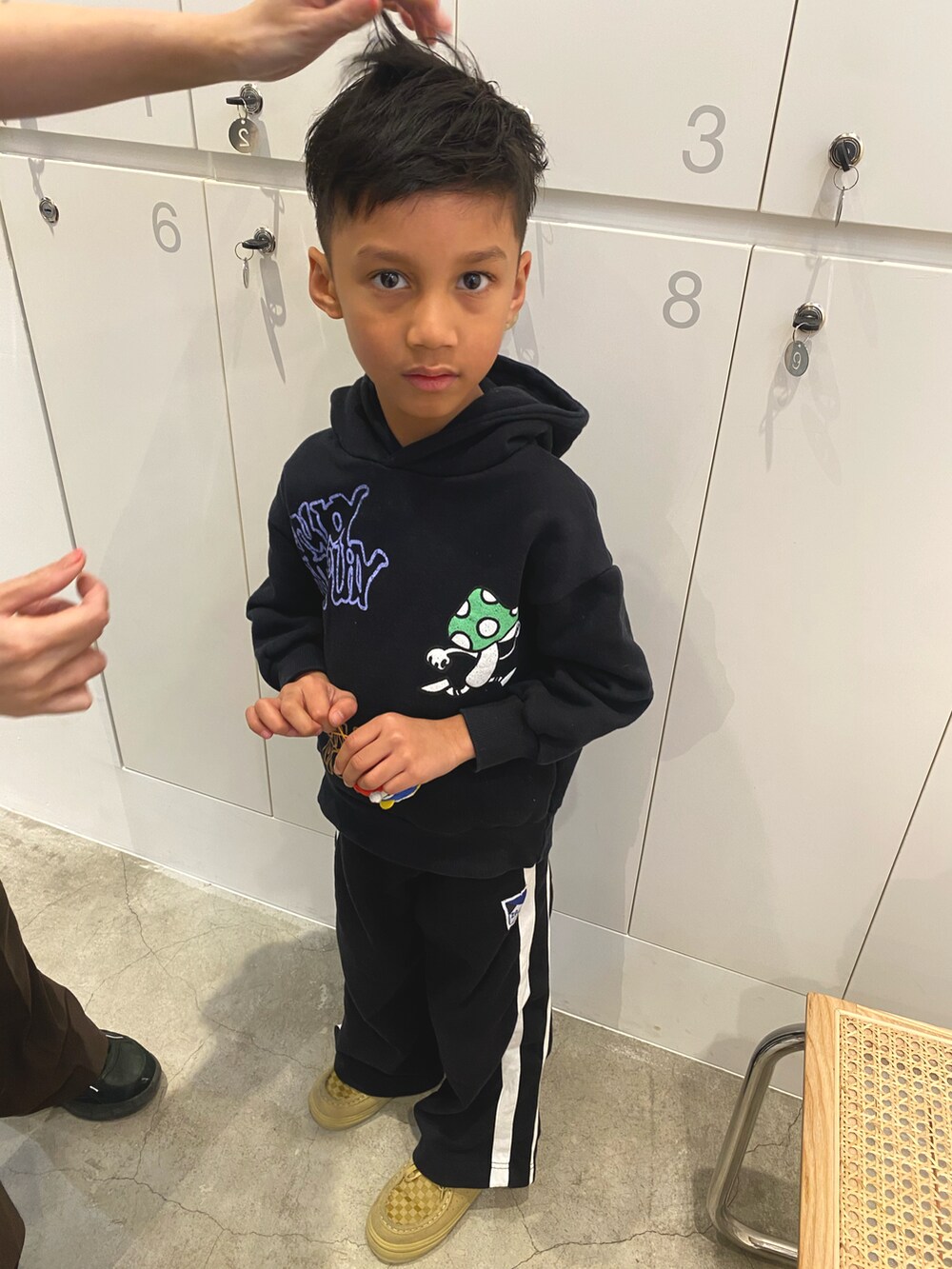 ベージュ系のスニーカー、ブラック系のパーカーを着用したキッズの冬コーディネートの3枚目の写真