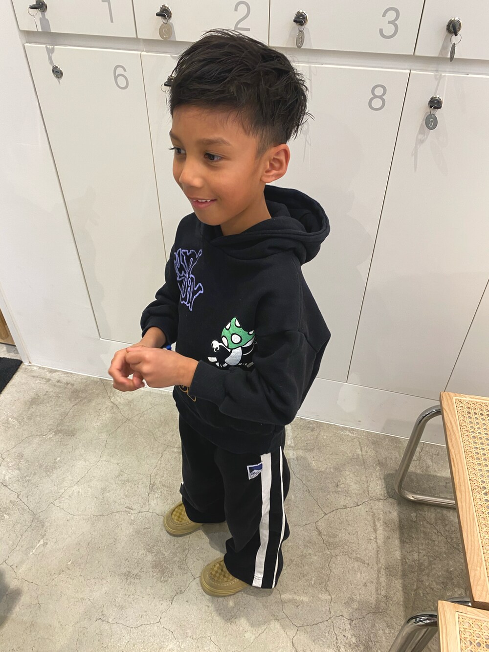 ベージュ系のスニーカー、ブラック系のパーカーを着用したキッズの冬コーディネートの2枚目の写真