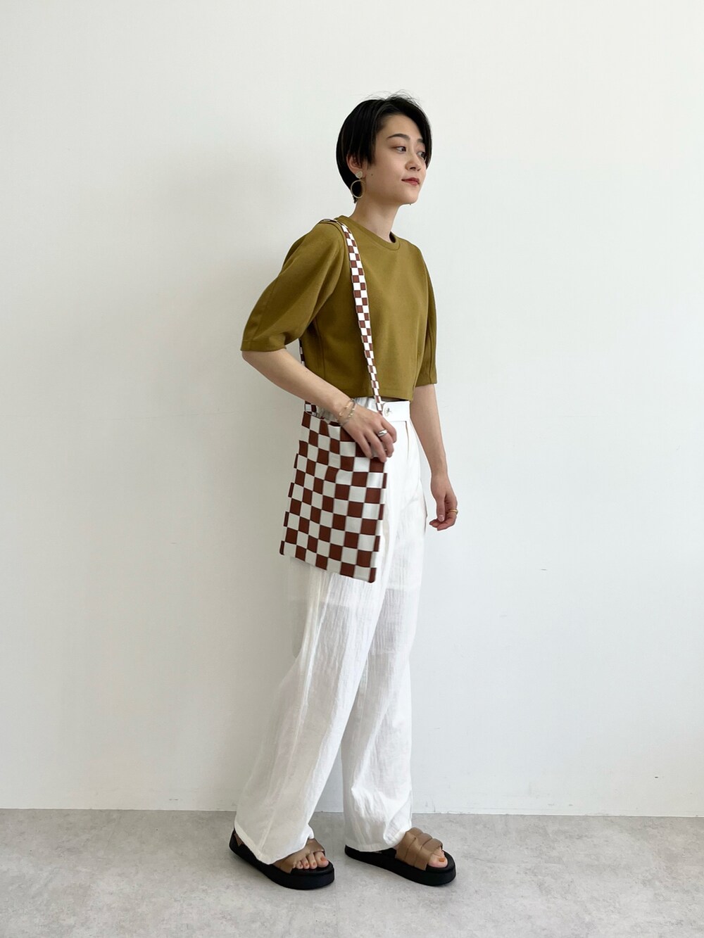 イエロー系のTシャツ/カットソー、ブラウン系のトートバッグ、ホワイト系のその他パンツを着用したレディースの春コーディネートの3枚目の写真