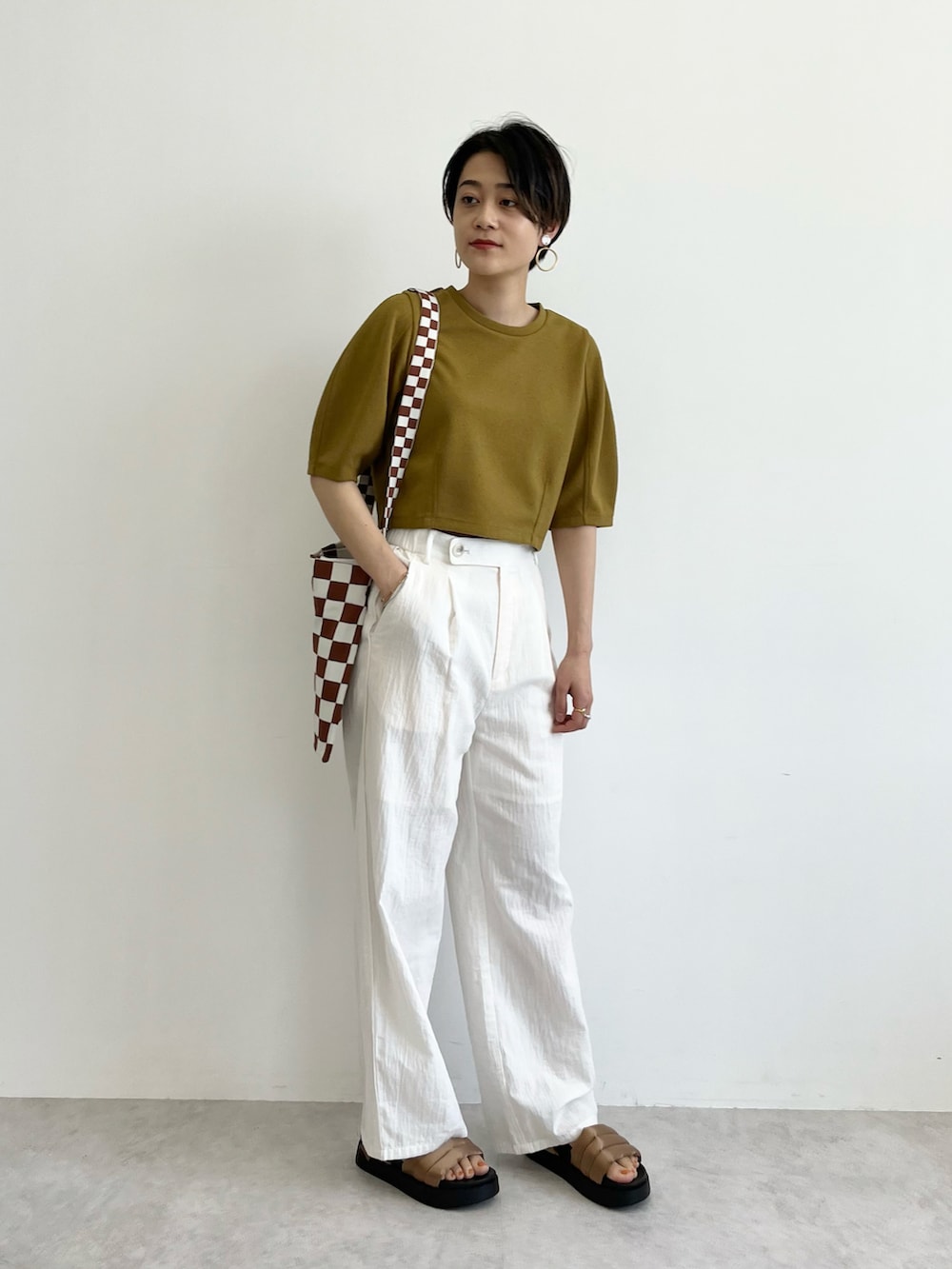 イエロー系のTシャツ/カットソー、ブラウン系のトートバッグ、ホワイト系のその他パンツを着用したレディースの春コーディネートの2枚目の写真