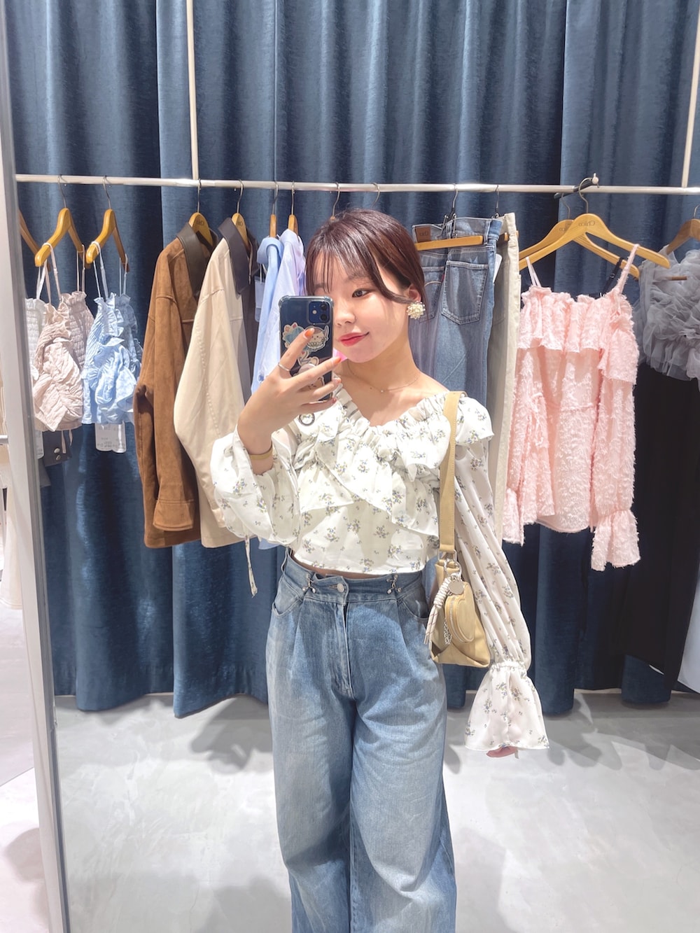 ホワイト系のシャツ/ブラウス、ベージュ系のショルダーバッグ、ブルー系のデニムパンツを着用したレディースの春コーディネートの3枚目の写真