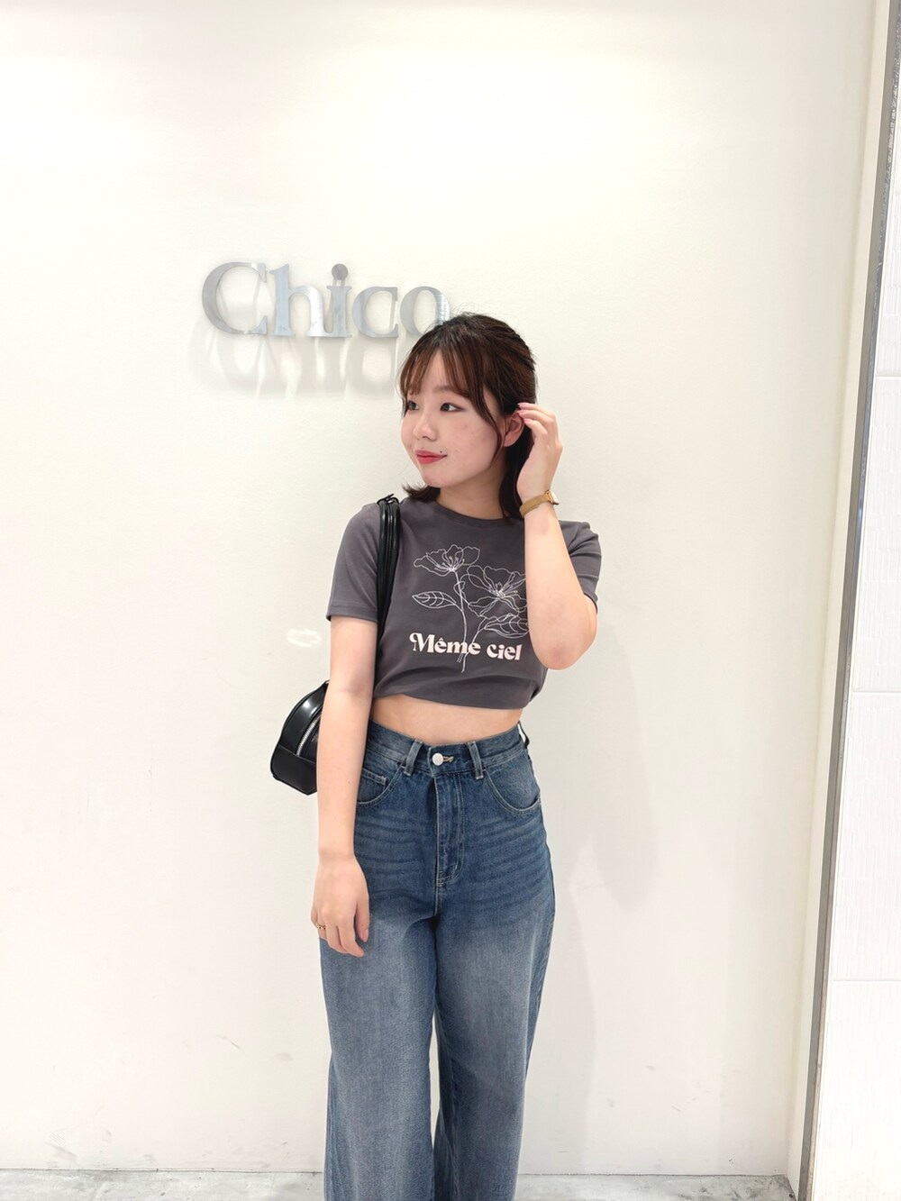 ブルー系のデニムパンツ、グレー系のTシャツ/カットソー、ブラック系のボストンバッグを着用したレディースの春コーディネートの2枚目の写真