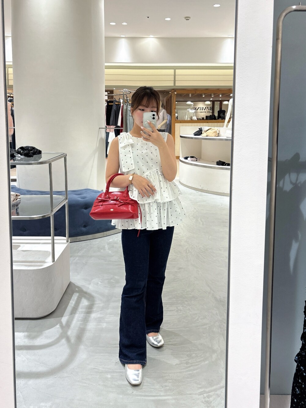 ホワイト系のシャツ/ブラウス、レッド系のボストンバッグ、ブルー系のデニムパンツを着用したレディースの夏コーディネートの3枚目の写真