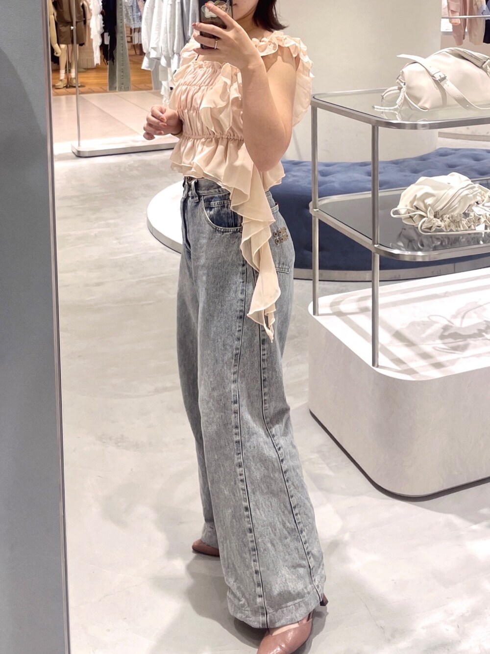 ピンク系のシャツ/ブラウス、ブルー系のデニムパンツを着用したレディースの春コーディネートの4枚目の写真