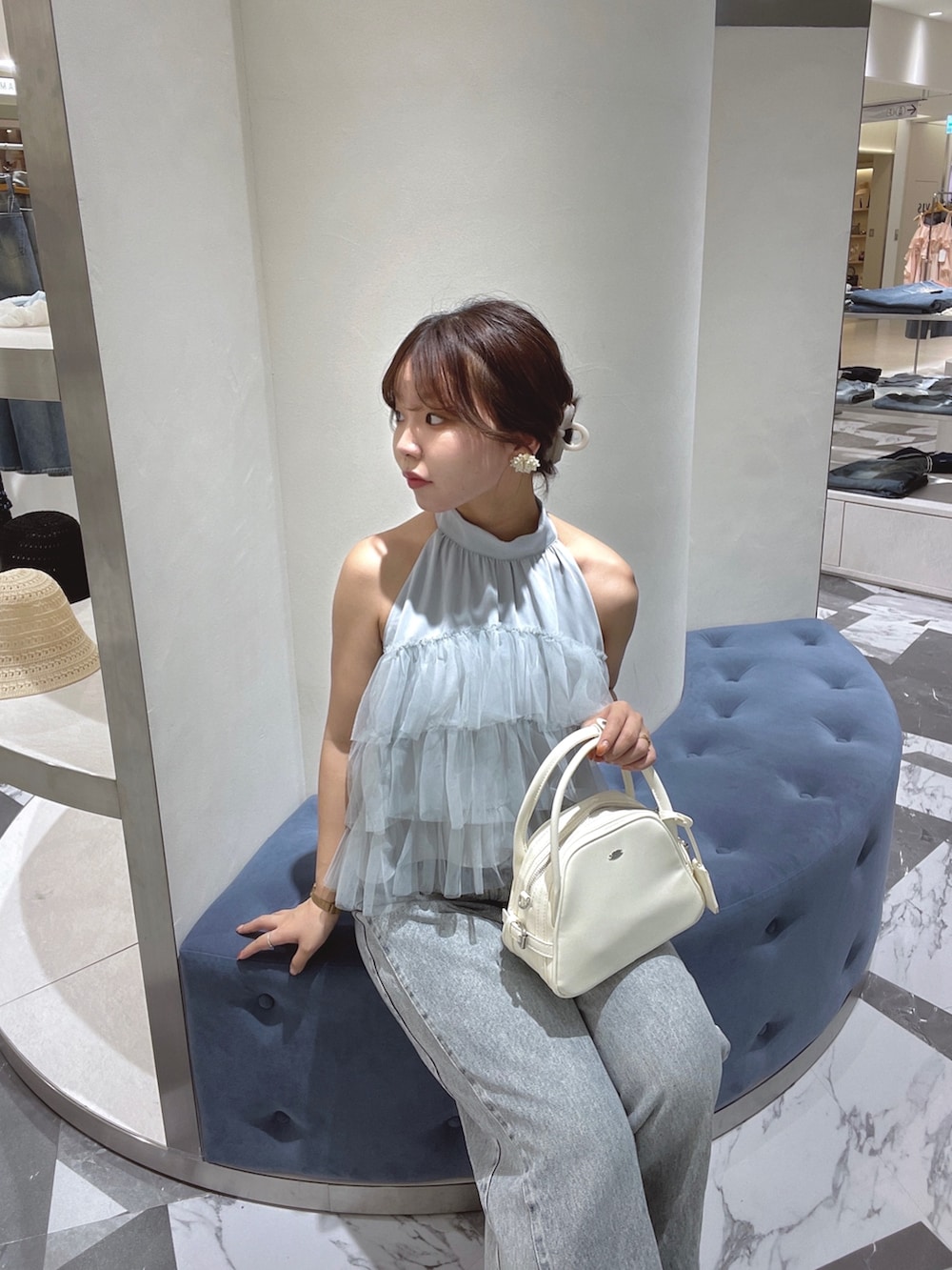 ブルー系のシャツ/ブラウス、ホワイト系のボストンバッグ、ブルー系のデニムパンツを着用したレディースの春コーディネートの3枚目の写真