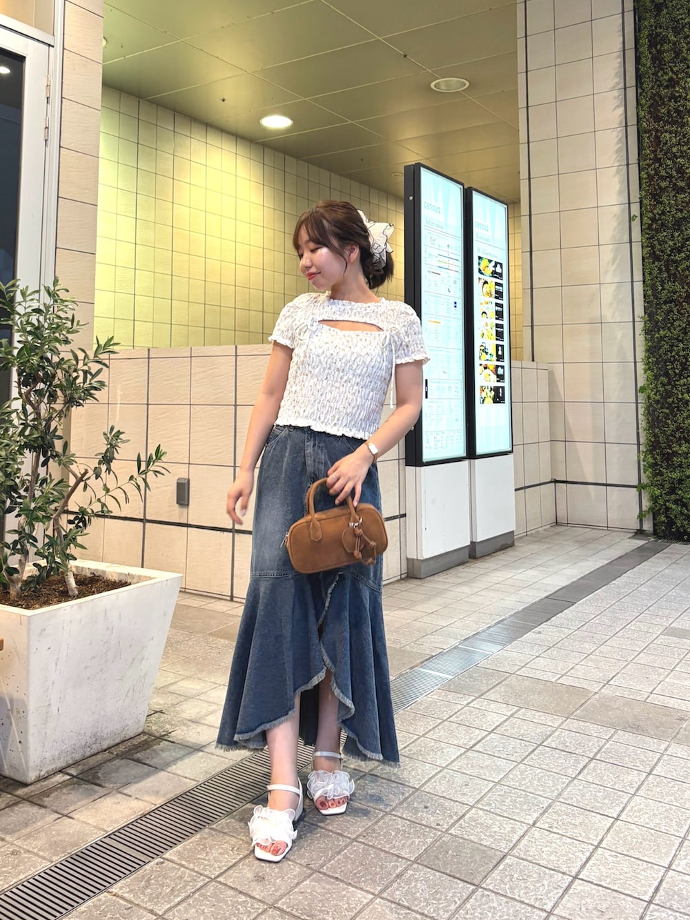 ブルー系のスカート、ホワイト系のTシャツ/カットソー、ベージュ系のボストンバッグを着用したレディースの夏コーディネートの4枚目の写真