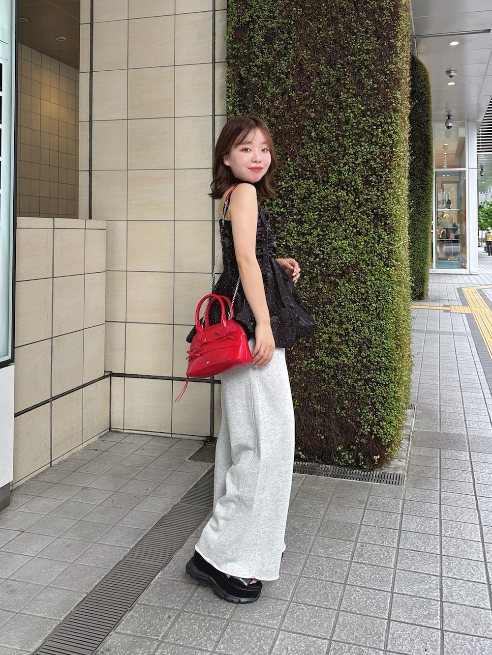 ブラック系のシャツ/ブラウス、レッド系のボストンバッグ、ベージュ系のスウェットパンツを着用したレディースの夏コーディネートの4枚目の写真