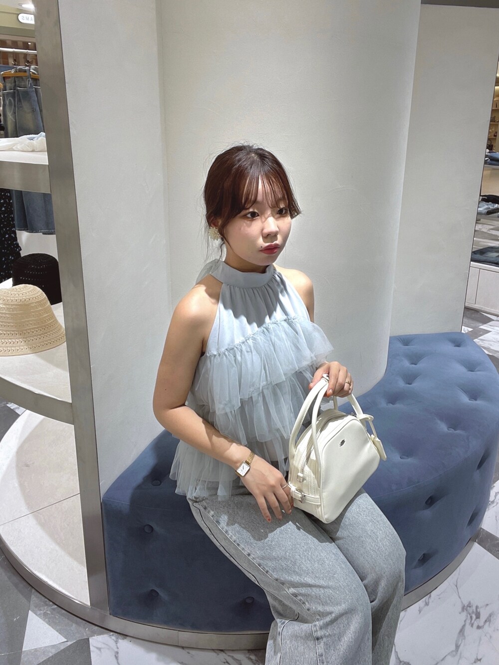 ブルー系のシャツ/ブラウス、ホワイト系のボストンバッグ、ブルー系のデニムパンツを着用したレディースの春コーディネートの2枚目の写真