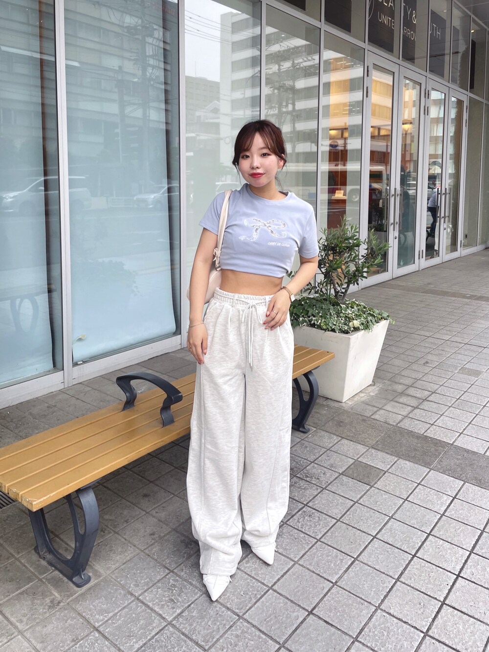 ブルー系のTシャツ/カットソー、ベージュ系のその他パンツ、ホワイト系のパンプスを着用したレディースの春コーディネートの2枚目の写真