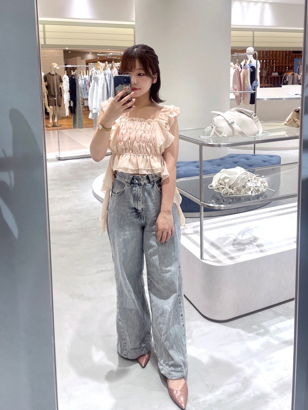 ピンク系のシャツ/ブラウス、ブルー系のデニムパンツを着用したレディースの春コーディネートの2枚目の写真