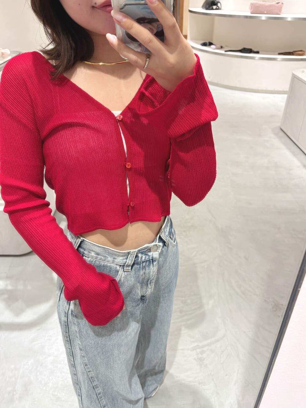 レッド系のカーディガン/ボレロ、ブルー系のデニムパンツ、シルバー系のキャミソールを着用したレディースの夏コーディネートの3枚目の写真