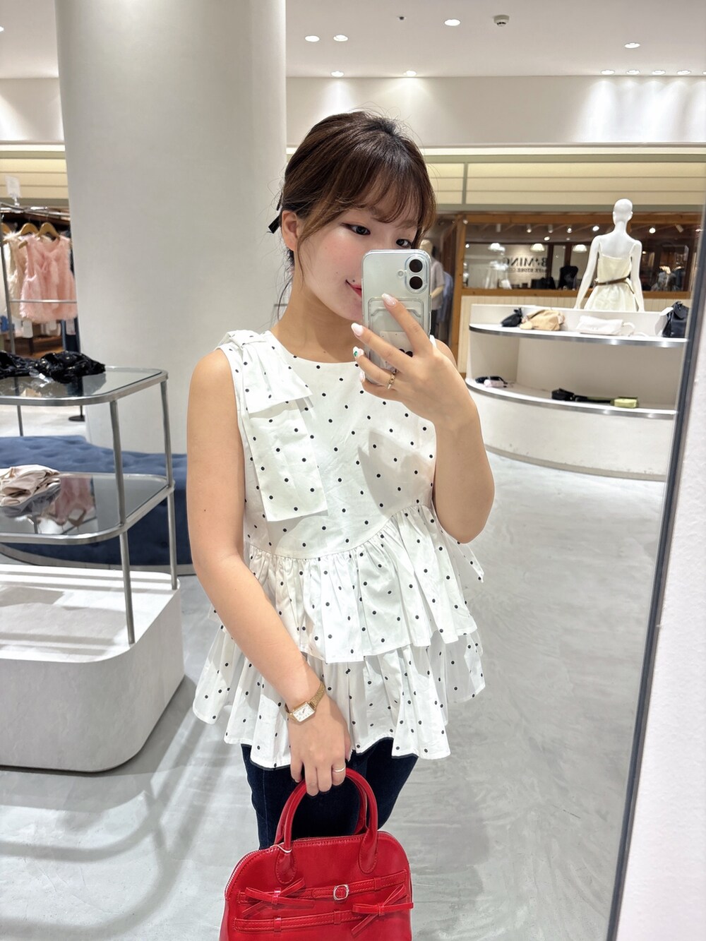 ホワイト系のシャツ/ブラウス、レッド系のボストンバッグ、ブルー系のデニムパンツを着用したレディースの夏コーディネートの2枚目の写真