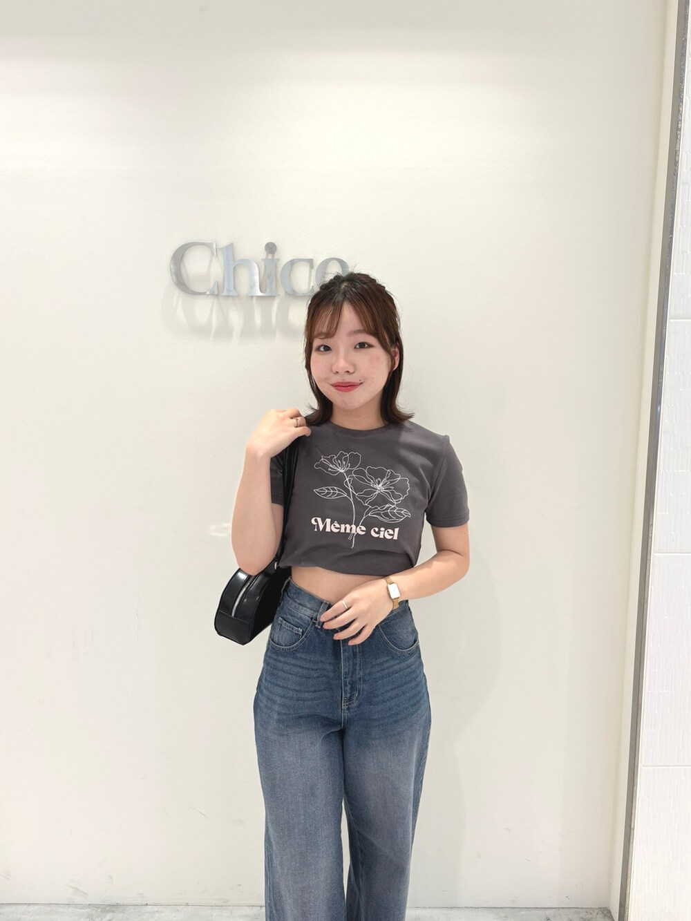 ブルー系のデニムパンツ、グレー系のTシャツ/カットソー、ブラック系のボストンバッグを着用したレディースの春コーディネートの3枚目の写真