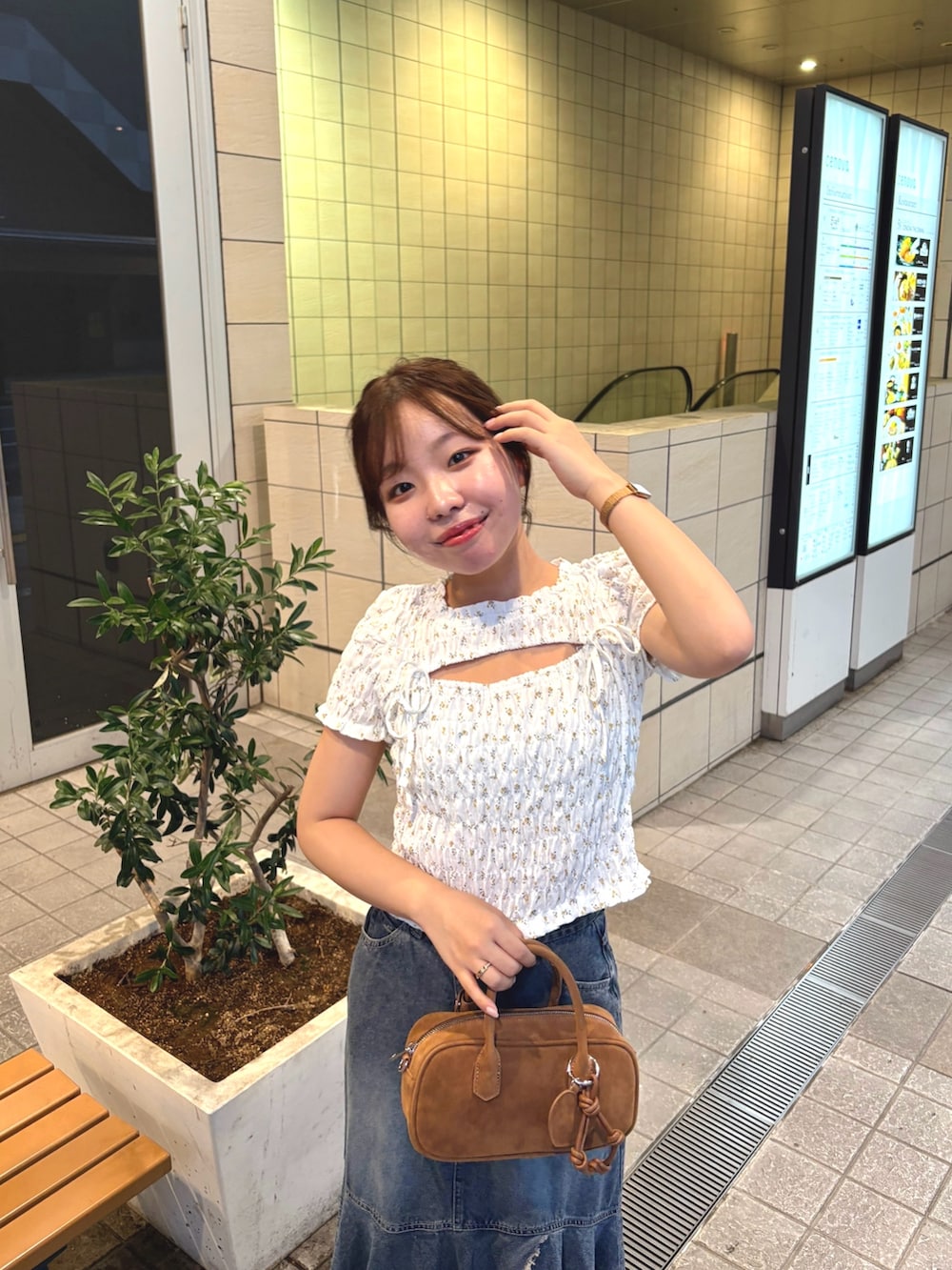ブルー系のスカート、ホワイト系のTシャツ/カットソー、ベージュ系のボストンバッグを着用したレディースの夏コーディネートの3枚目の写真
