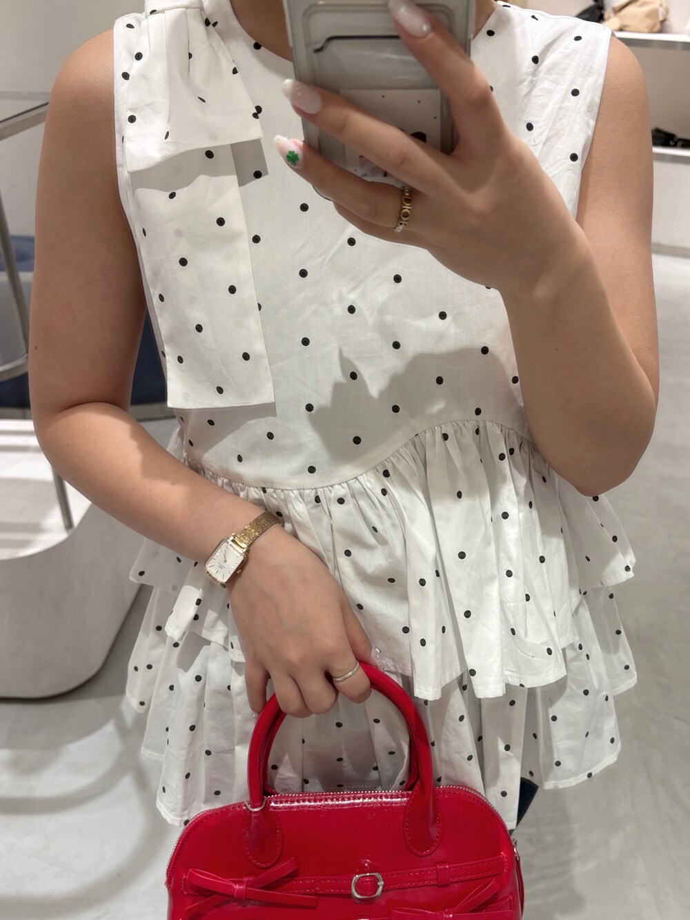 ホワイト系のシャツ/ブラウス、レッド系のボストンバッグ、ブルー系のデニムパンツを着用したレディースの夏コーディネートの4枚目の写真