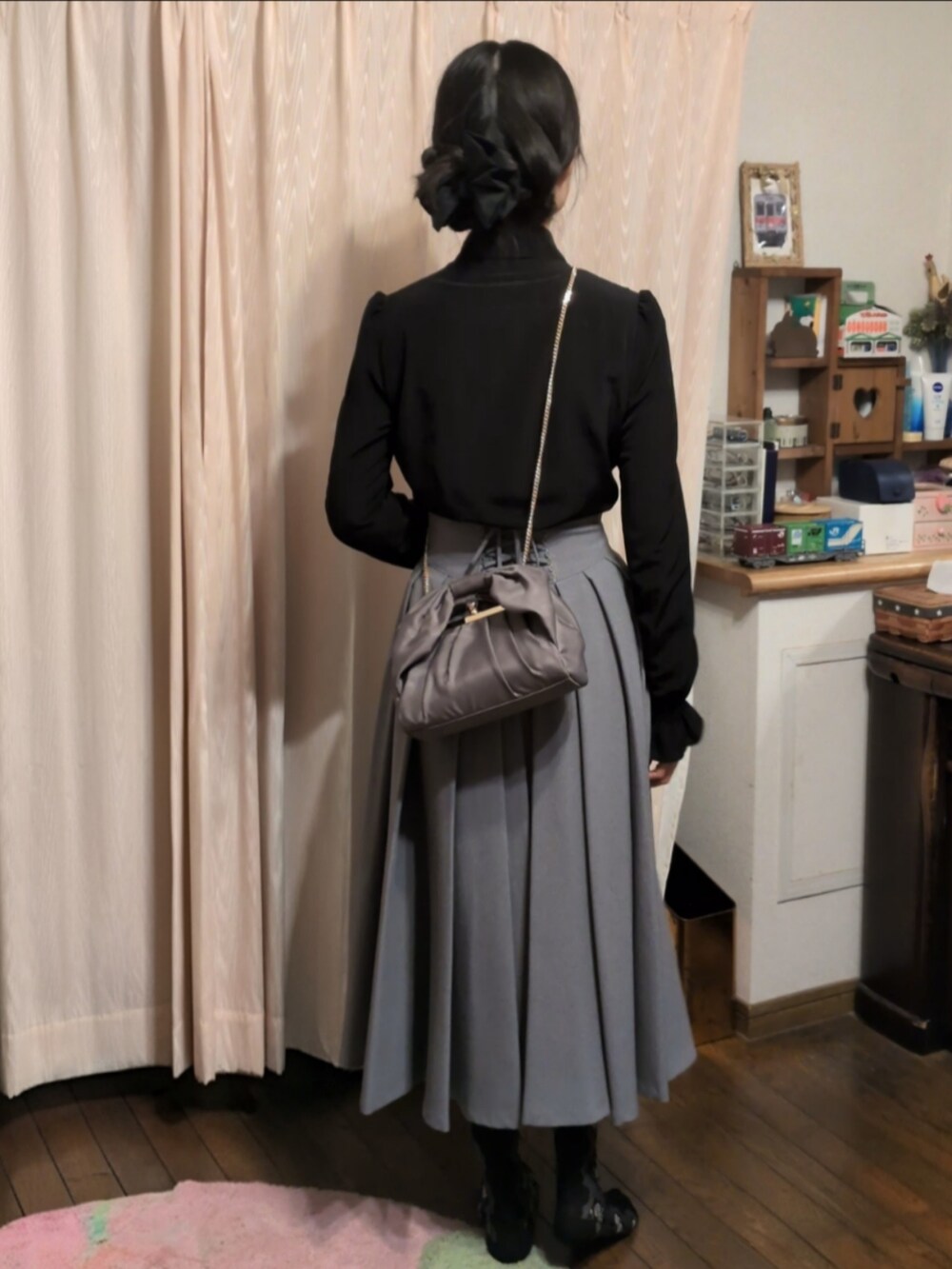 ブラック系のシャツ/ブラウス、グレー系のスカート、グレー系のハンドバッグを着用したレディースの冬コーディネートの2枚目の写真