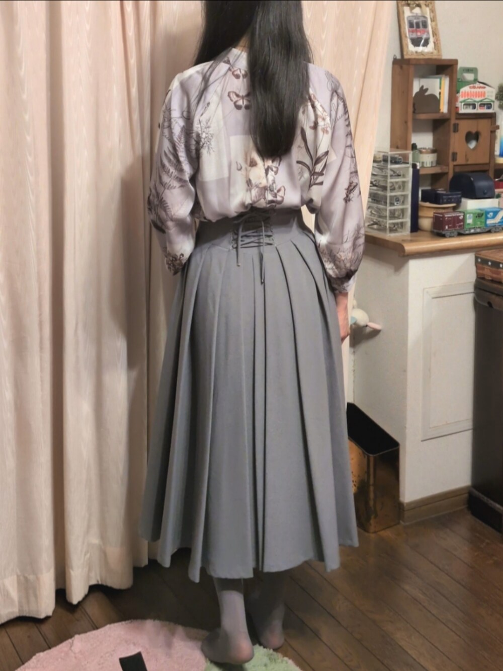 グレー系のスカート、グレー系のシャツ/ブラウス、ゴールド系のネックレスを着用したレディースの春コーディネートの2枚目の写真